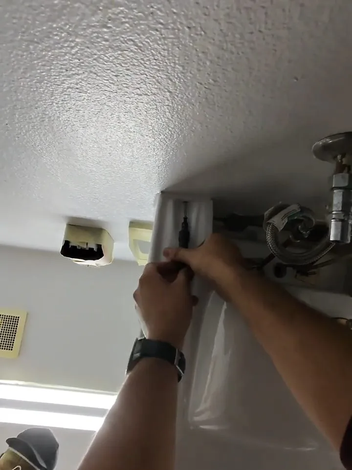 Contractor installing restroom ceiling drain on a San Tan Valley job site